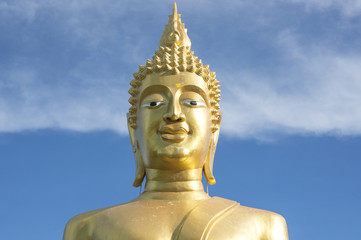 Fototapeta na wymiar Great Golden Buddha statue in the temple with blue sky and white cloud in Thailand 