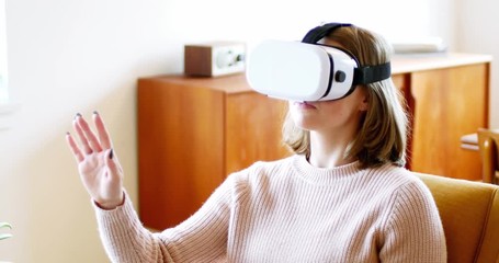 Woman using virtual reality headset in living room - Powered by Adobe