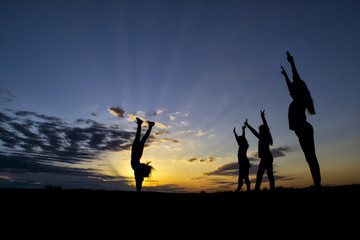 Kids having a gymnastic competition at sunset