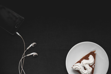 Chocolate cake with headphones on a black background