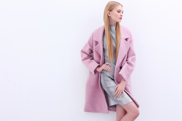 Young elegant woman in trendy pink coat.