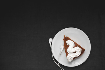 Chocolate cake with headphones on a black background