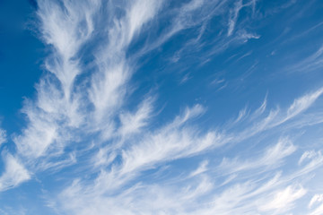 White clouds of unusual shape on a blue sky in winter