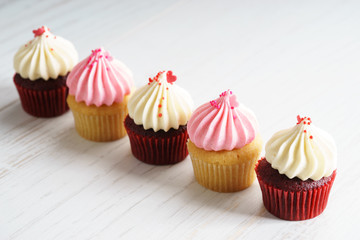 colorful cupcakes on white wooden background