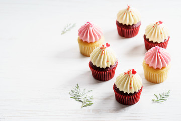 colorful cupcakes on white wooden background