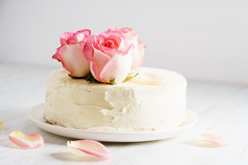 sweet white buttercream cake with pink rose flowers on top