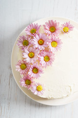 Fototapeta na wymiar sweet white buttercream cake with pink flowers on top