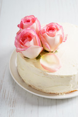 sweet white buttercream cake with pink rose flowers on top