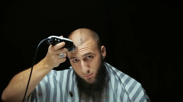 Close-up of a using clippers to shave head.