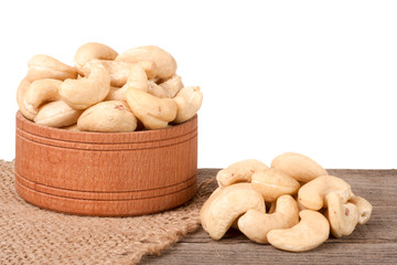 cashew nuts in a wooden bowl on the board isolated white background