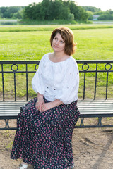 woman sitting on bench in summer park