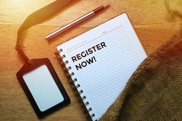 Business Concept, Top view shows the name tags, pens, and notebooks written Register Now