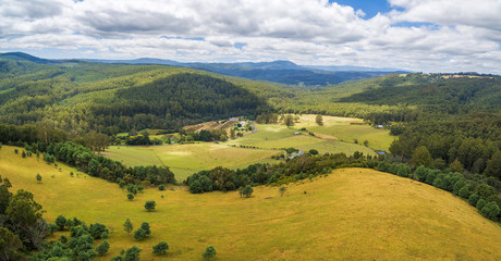 Aerial panorama of beautiful countryside with pastures and forested hills