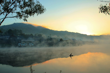 Obraz na płótnie Canvas village in mist with lake