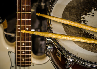 snare drum with drumsticks and bass guitar