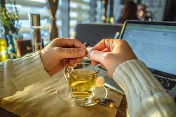 male sitiing in caffe drinking tea and working on laptop