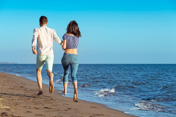happy couple running on the beach