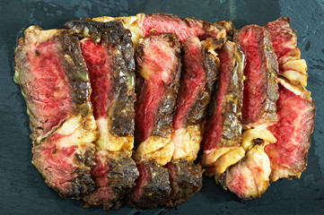 rib-eye steak with spices cut in slices, close-up