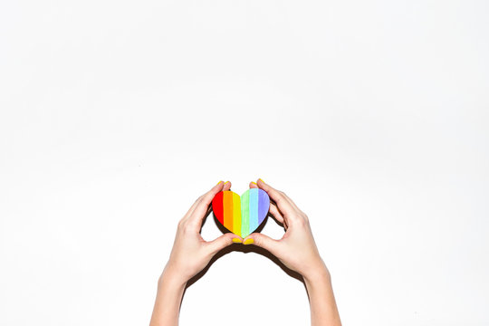 Woman's hand holding rainbow pride symbol