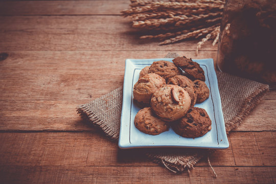 Cookie in white plate on hemp sack on wood table with copy space. vintage tone. Selective focus.