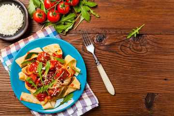 Italian pasta pappardelle with meatballs in tomato sauce.