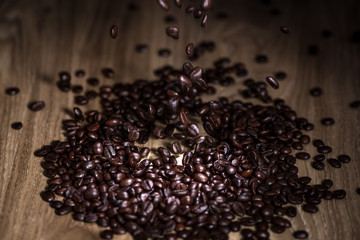 Dark coffee beans falling on the table