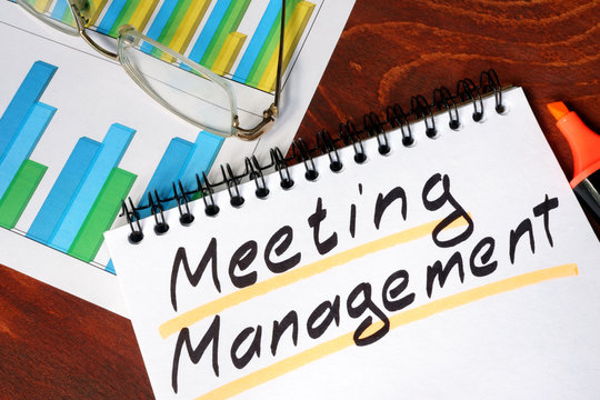 Notepad with Meeting Management on a wooden surface.