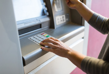 close up of hand entering pin code at atm machine