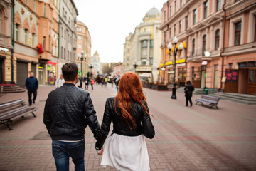 Couple holding hands and walking in street, boy and girl in love