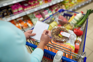 woman with food in shopping cart at supermarket