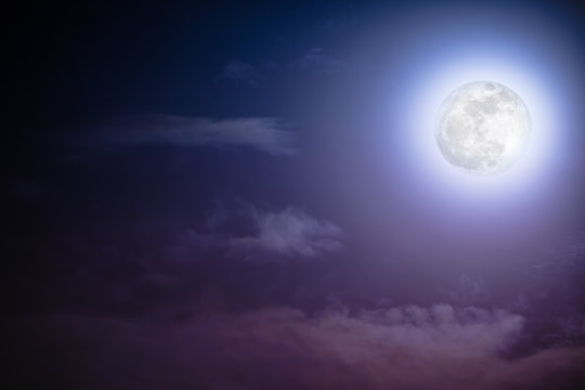 Nighttime sky with clouds and bright full moon with shiny.