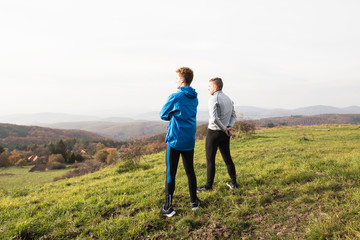 Two young hipster runners in sunny autumn nature restinng