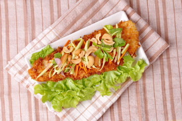 Spicy deep-fried Dolly's fish salad with roll green mango.