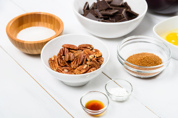 Pecan Nuts, Dark Chocolate Pieces, Sugar And Egg Yolk On Kitchen Table