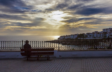 Fototapeta na wymiar Man sitting at Balcon de Europa, Nerja, Spain