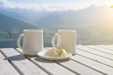 Two cups of tea with lemon on a table in a cafe in the mountains