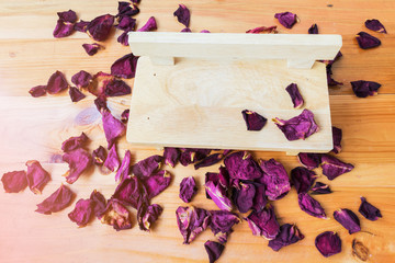 dried red petals rose, on a decorative chair made from wood