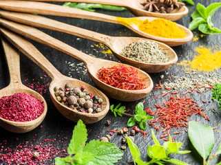 Assortment of colorful spices in the wooden spoons.
