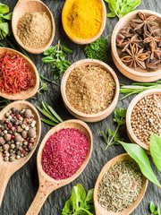Assortment of colorful spices in the wooden spoons.