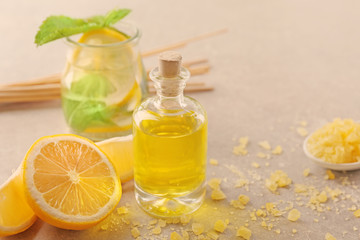 Beautiful spa composition with lemon essential oil on gray background, closeup