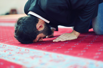 Obraz premium Younger Muslim man praying in colorful mosque