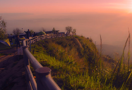 Morning Sunlight over mountain range at Phu Thub Berg National Park, Phetchaboon, Thailand.A golden sunrise through the trees in a forest over the valley in thailand