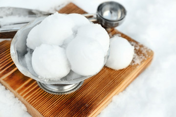 Fototapeta na wymiar Vintage ice cream bowl with snowballs on wooden board outdoors
