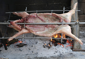 pig on the spit and slowly cooked on the large fireplace during