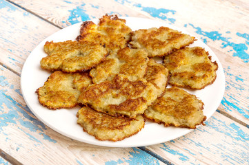 Plate with potato pancakes on the table.