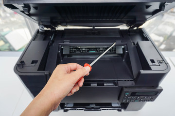 engineer with screwdriver for printer maintenance