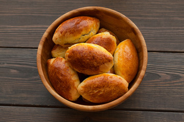 Traditional russian patties in a bowl on a wooden background.