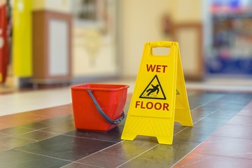 Warning yellow plastic sign of wet floor.