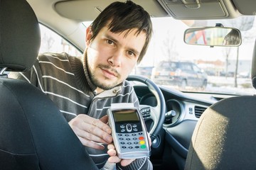 Paying for transportation. Taxi driver is offering payment terminal to customer.