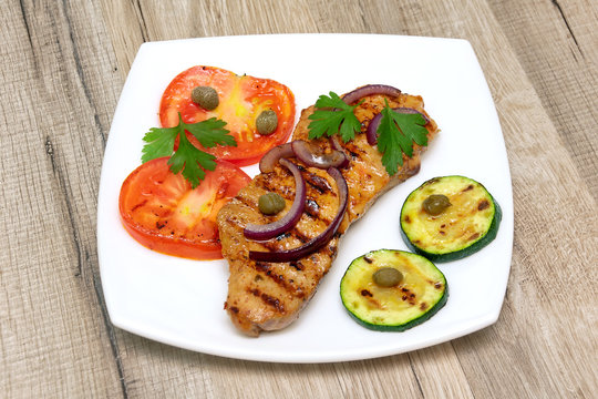 grilled meat with vegetables on a wooden background